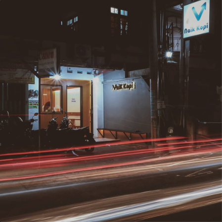 Post Oktober 2019: fasad Naik Kopi di malam hari dengan light trail